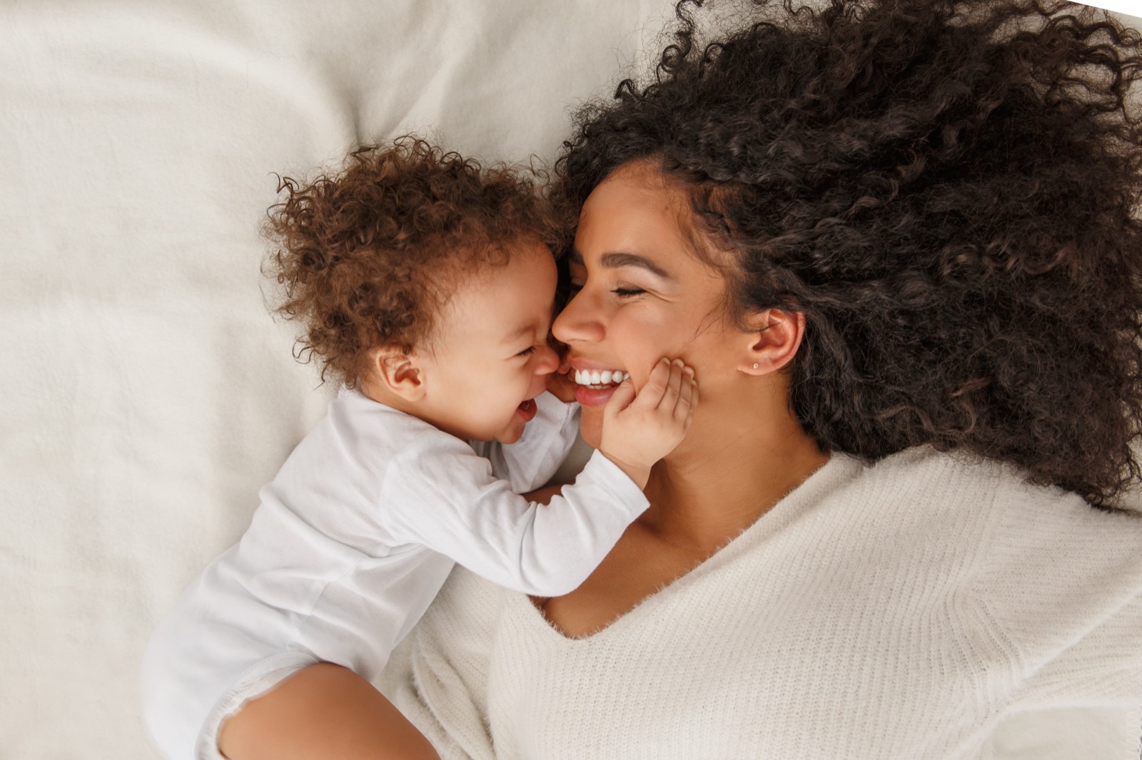 A mother holding her laughing infant